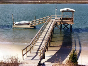 A pier leading to a deck and floating dock on inlet